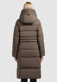 Gewatteerde bruine jas met een hoge kraag en grote capuchon, met een smal taille en een knielange snit en horizontale stikdetails.