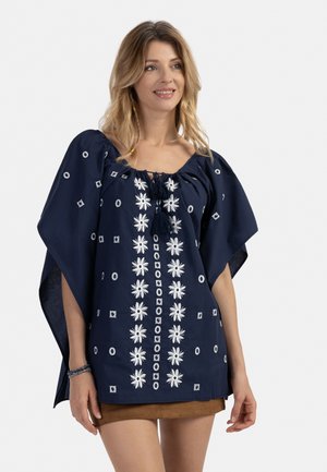 Top ricamato blu navy con maniche a cappotto corte, caratterizzato da disegni floreali e geometrici bianchi, scollo con coulisse e tessuto testurizzato.