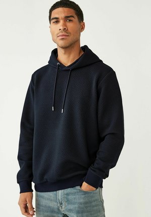 Marineblå hætte sweatshirt lavet af tekstureret stof med diamantmønster. Har snoretræk og ribbede manchetter for en tæt pasform.