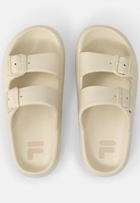 Sandali FILA color crema, realizzati in plastica testurizzata, con due cinghie regolabili, dotati di una soletta sagomata e un sottile dettaglio del logo.