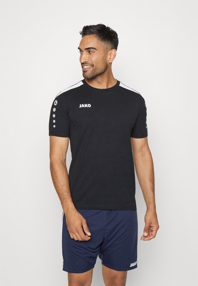 Zwart sport T-shirt met witte zijkanten, korte mouwen en het "JAKO" logo op de borst. Bevat ronde accenten op de schouder.