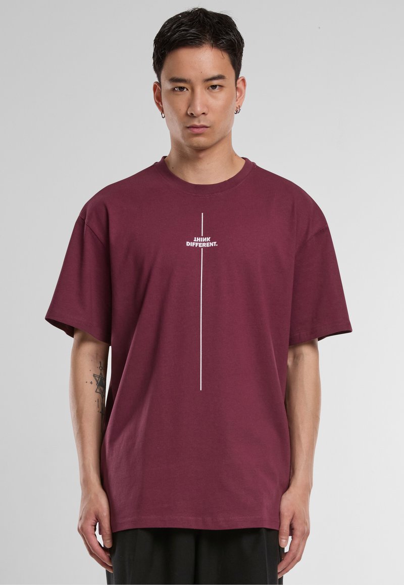 Burgundy cotton t-shirt with short sleeves, featuring a horizontal white text graphic that reads "I THINK DIFFERENT." Centered design.