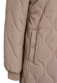 Beige värillisessä tikatussa takissa on teksturoitu aaltoileva kuvio, joustavat hihansuut ja sivutasku, jossa on nepparikiinnitys. Pehmeä, toppattu materiaali.