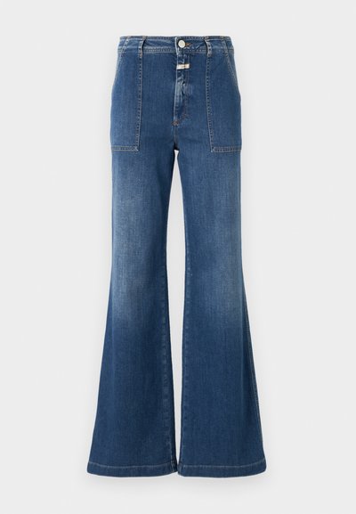 Visoko pasane razširjene kavbojke iz srednje modrega denima z zbledelim zaključkom. Imajo žepe s priponkami in gumb zaprte. Čist rob.