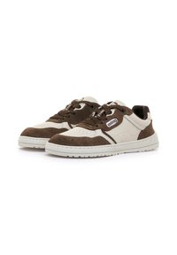 Niedrige Sneakers in Creme und Braun mit weißen Sohlen, Schnürsenkeln und einem seitlichen Etikett mit der Aufschrift "mtng", schräg vor einem weißen Hintergrund präsentiert.