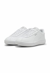 Adidași albi din material sintetic neted, cu vârf rotunjit și talpă din cauciuc plat. Prezintă închidere cu șireturi și un accent discret cu logo pe lateral.