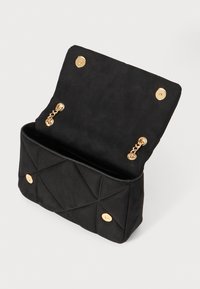 Black suede handbag with a textured quilted design, gold hardware accents, and a flap closure. Interior features a spacious compartment.