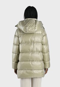 Giacca verde oliva puffa con cappuccio staccabile, finitura lucida, cuciture orizzontali e maniche lunghe per un maggiore calore.