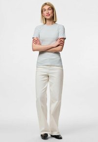 Randig bomullströja i ljusblått och vitt, kort ärm, figurnära design. Kombineras med högmidjade vita vida byxor och svarta lägenheter.