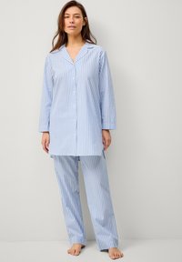 Lichtblauw en wit gestreept pyjama set, bestaat uit een overhemd met knopen, een kraag en lange mouwen, gecombineerd met bijpassende losse broek.