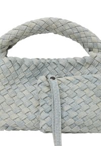 Borsa intrecciata in blu chiaro e crema. Presenta una trama intrecciata, manico arrotondato e una piccola tasca attaccata con chiusura.