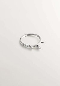 Pendiente de aro plateado que presenta tres picos puntiagudos y una fila de brillantes transparentes, con un acabado de metal liso, forma circular y diseño abierto.