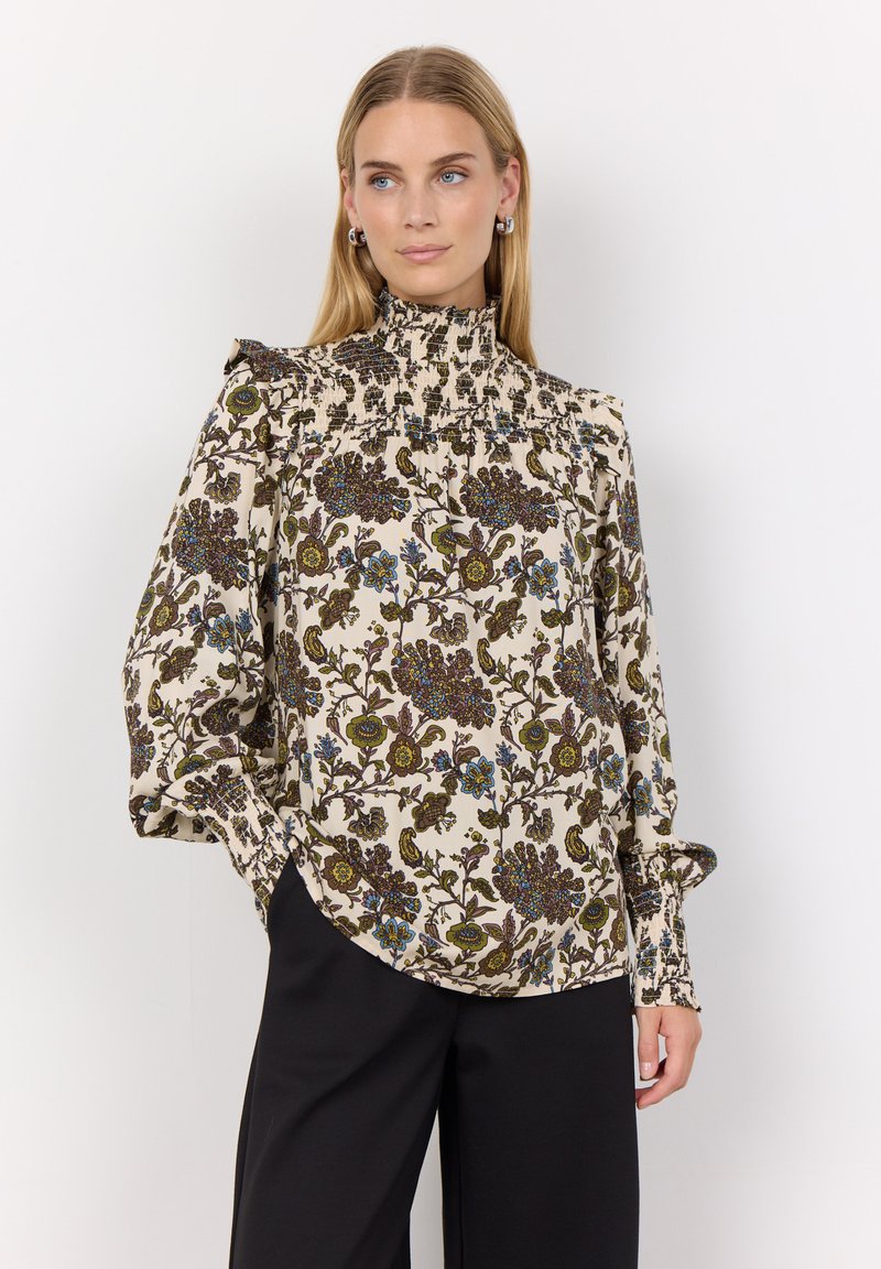 Floral blouse with a high neck, light beige background, and rich dark green, blue, and brown patterns. Features gathered sleeves and cuffs.