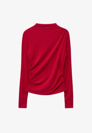 Red long-sleeve top, made from smooth fabric with draped detail on the back, featuring a high neckline and fitted sleeves.