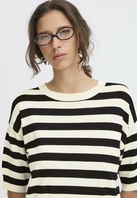 Maglione a righe nere e crema con scollo tondo e maniche corte, caratterizzato da una texture morbida e una vestibilità rilassata.