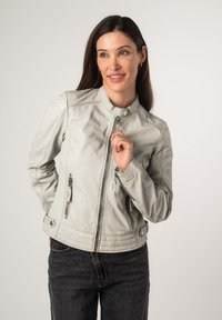Giacca di pelle grigia chiara con colletto rialzato, chiusura frontale con zip e tasche laterali con zip. Presenta un design aderente e una texture liscia.