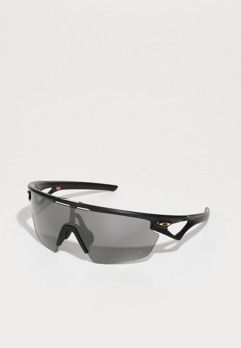 Sportliche Sonnenbrille mit einem schwarzen Kunststoffrahmen, grauen getönten Gläsern, aerodynamischem Design und markanten Aussparungen an den Bügeln.