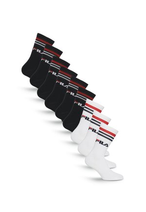 Sept paires de chaussettes FILA noires et blanches avec des rayures rouges et grises, disposées en rangée diagonale décalée sur fond blanc.