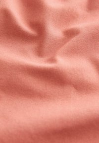 Tissu rose clair présentant une texture lisse avec une surface légèrement froissée et un motif de tissage fin. Un éclat subtil renforce la profondeur visuelle.