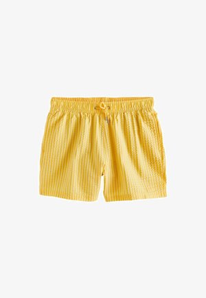 Kollased ujumispüksid vertikaalsete valgete triipudega, elastse vöökohaga ja ees metallotsikutega paelaga.