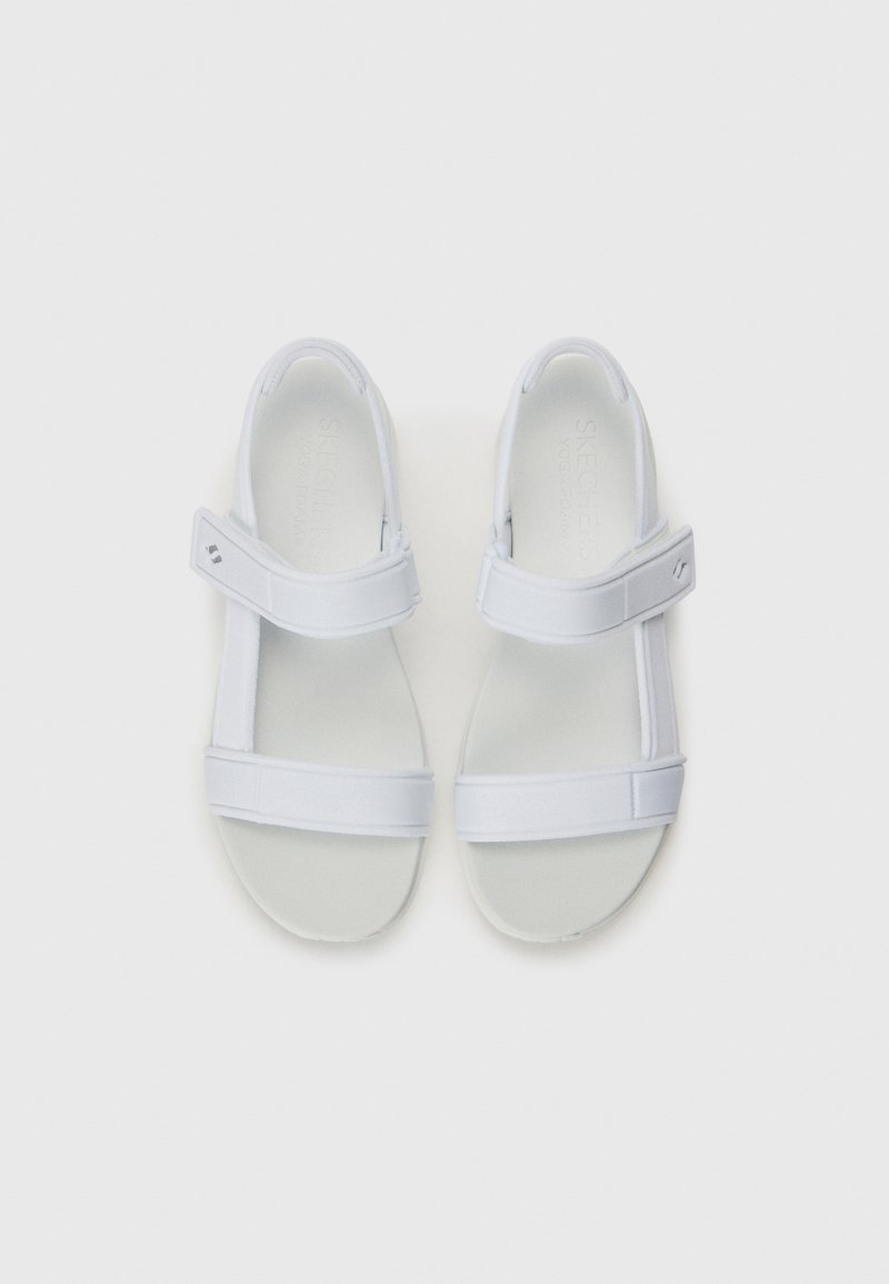 Sandalias blancas con dos correas ajustables, que cuentan con una textura suave y una plantilla acolchada. Diseño minimalista con una forma de puntera redonda.