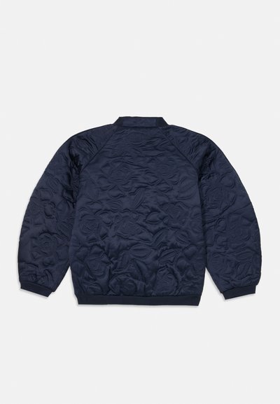 Marineblå quiltet jakke med rose mønstre, ribbestrikkede mansjetter og krage, samt en glatt tekstur. Har raglanermer for bedre bevegelsesfrihet.