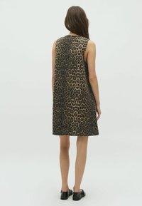 Abito senza maniche con stampa leopardata in tonalità di marrone e nero, con taglio dritto, dettagli di cucitura visibili e chiusura sul retro.