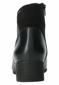 Bottine noire avec une tige en cuir lisse et en daim, bout rond et talon empilé. Zip latéral pour une mise enfilage facile. Semelle texturée.