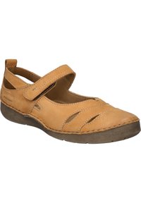 Zapato Mary Jane de cuero marrón claro con una sola tira de Velcro, cortes abiertos en los laterales y una suela de goma marrón oscuro en contraste. Detalles de costura en todo el calzado.