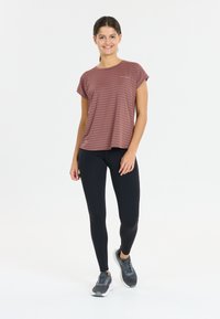 Lyhythihainen viininpunaraitainen paita, joka on yhdistetty mustiin legginsseihin ja harmaisiin urheilukengiin. Paidassa on rento malli ja pehmeä texture.