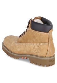 Bruine, suède enkelboot met een gewatteerde zwarte kraag, vetersluiting en een robuuste rubberen zool met een logo-patch en stiksel-details.