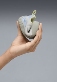 Flexible sneaker in light blue, gray, and green. Structured design with perforated accents. Soft materials suitable for flexible movement.