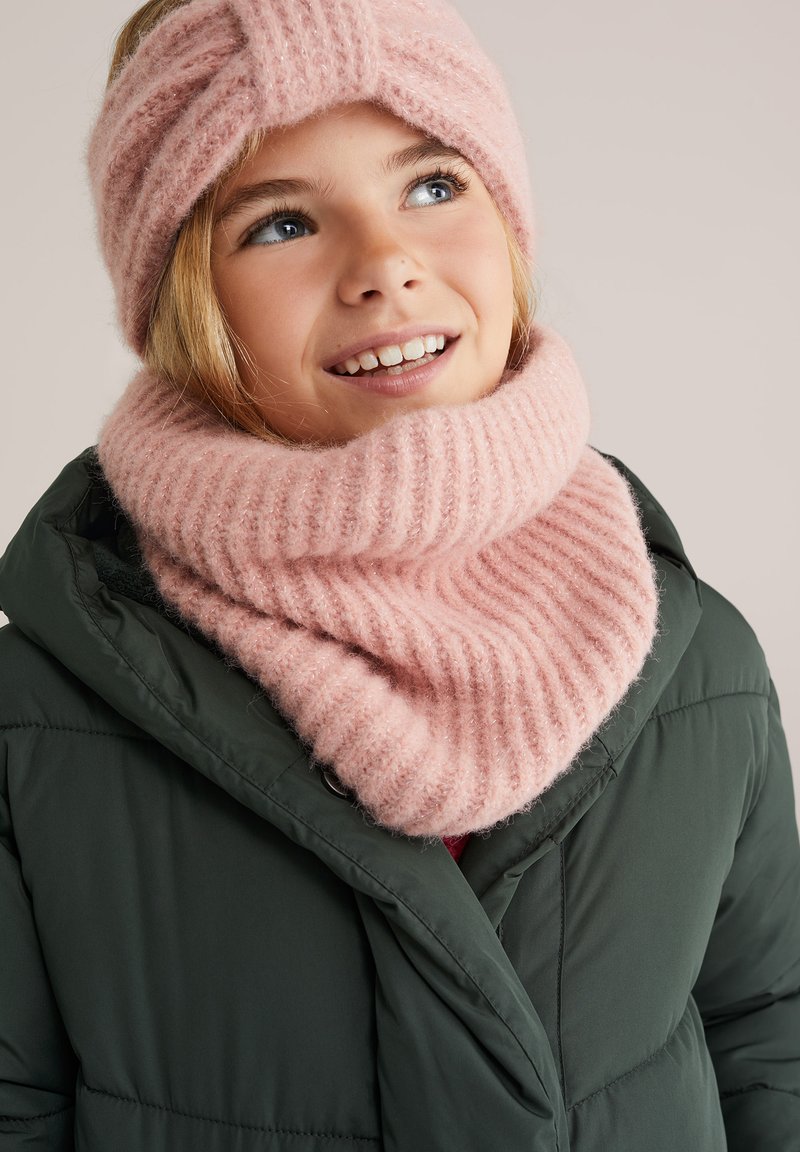 Vaaleanpunainen neulottu pääbandi, jossa on kierretty muotoilu, ja siihen sopiva ribbikuvioinen huivi, käytettävänä tummanvihreän toppatakin kanssa. Pehmeä tekstuuri, mukava kerroksellisuus.