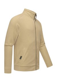 Giacca beige con zip, in tessuto a maglia testurizzata, colletto alto e tasche laterali. Presenta una zip a contrasto e un piccolo etichetta del marchio sul lato.