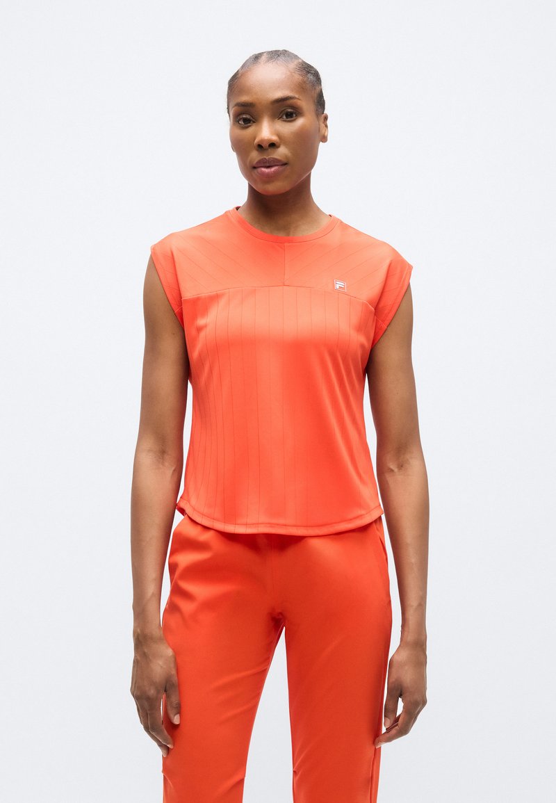 Πορτοκαλί αθλητικό τοπ με κοντά μανίκια και υφή στο μπροστινό μέρος, με κάθετες ρίγες και μικρό λογότυπο στο στήθος. Λεία ύφανση, άνετη εφαρμογή.