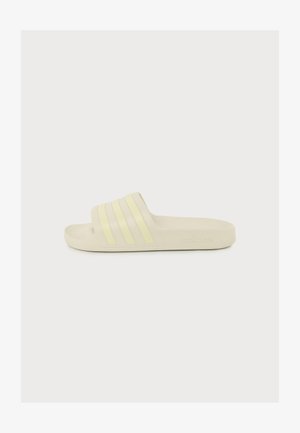 Sandale slide beige unique Adidas avec trois bandes jaune pâle sur la sangle et marquage en relief sur la semelle.