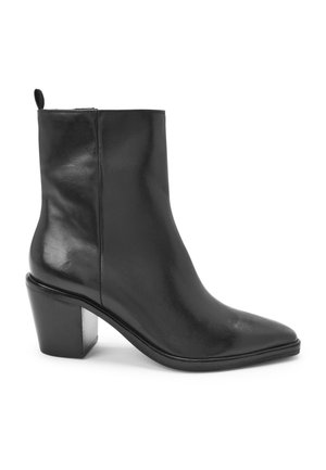 Bottine en cuir noir avec bout pointu, fermeture éclair latérale, talon bloc et languette à l'arrière.