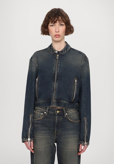 Donkerblauwe denimjack met een cropped ontwerp, een ritssluiting aan de voorkant en zakken, en een staande kraag. Beschikt over gestikte details en rafelige mouwen.