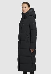 Sort duntjakke med et langt, lige design, der har hætte, lynlås-lommer og et struktureret quiltet mønster.