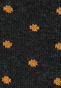 Tessuto nero con piccole ricamo a zigzag arancioni distribuiti uniformemente che formano un sottile motivo a pois.