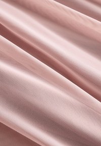 Rosa strukturierter Stoff mit sichtbarem Webmuster und weichen Falten, die diagonale Linien über die Oberfläche ziehen.