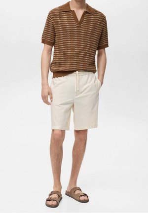 Polo en tricot rayé marron à col en V, associé à un short beige à cordon de serrage et des sandales marron. Tissu lisse et design décontracté.