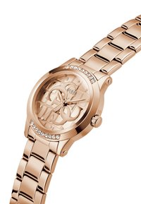 Roségoldene Uhr mit Kristallakzenten, rundem Gehäuse und ineinandergreifendem Logodesign auf dem Zifferblatt. Metallarmband mit polierter Oberfläche.