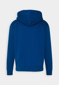 Modrá mikina s kapucí vyrobená z měkkého materiálu, s jednoduchým designem, žebrovanými manžetami a volným střihem. Žádné viditelné logo ani vzory.