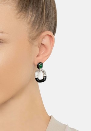 Green stone stud with a silver band, featuring black and silver accents in an open oval shape. Smooth texture, modern design.
