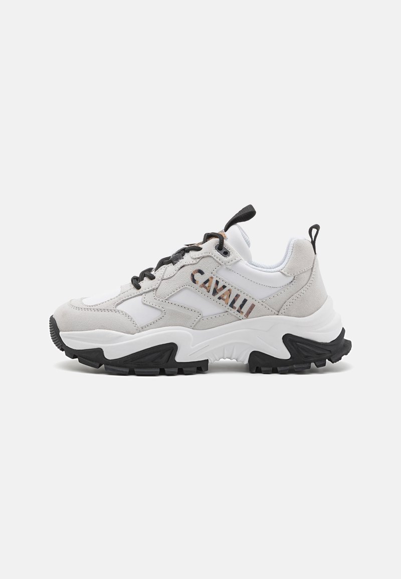 Masivne športne superge, ki združujejo belo usnje in sivo semiš, imajo črno gumijasto podplat, zavezovanje z vezalkami in logotipno podrobnost na strani.