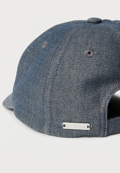 Casquette de baseball en denim bleu avec sangle ajustable et petite étiquette argentée "SANDRO" sur le panneau arrière.