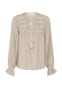Beige Bluse mit langen Ärmeln, gerafften Details am Oberteil und einer Quasten-Nackenband. Sie verfügt über strukturierte Akzente entlang der Ärmel.
