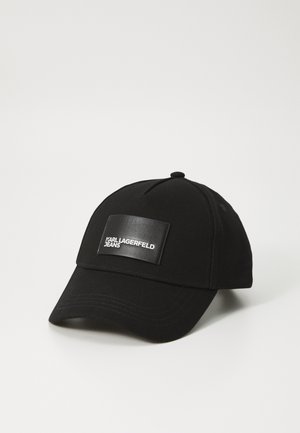 Gorra de béisbol negra de tela, con un parche rectangular brillante negro que lleva la inscripción "KARL LAGERFELD JEANS" en relieve blanco.