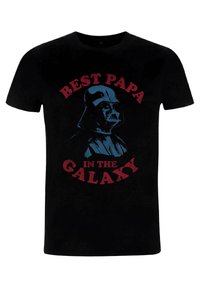 Černé bavlněné tričko s potiskem helmu nosící postavy a nápisem "NEJLEPŠÍ TATA V GALAXII" v červené a modré barvě.